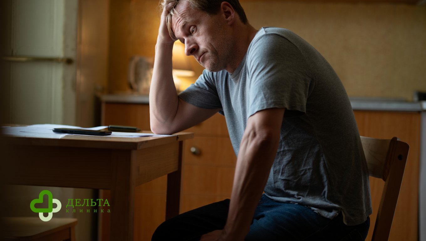 Мужчина смотрит на стакан виски